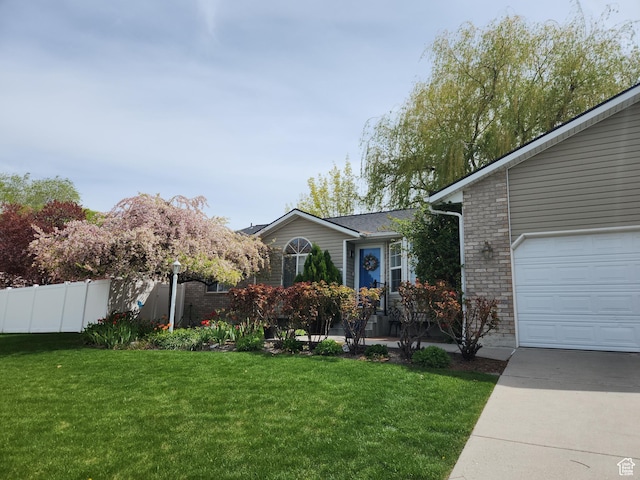 5149 W Village Wood Dr, West Valley City, UT 84120 - view of front of property with a garage, concrete driveway, and brick siding
