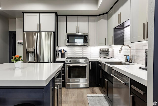 6627 Mountain Alder Way, Park City, UT 84098 - kitchen with stainless steel appliances, light countertops, light wood-style floors, tasteful backsplash, and a kitchen island