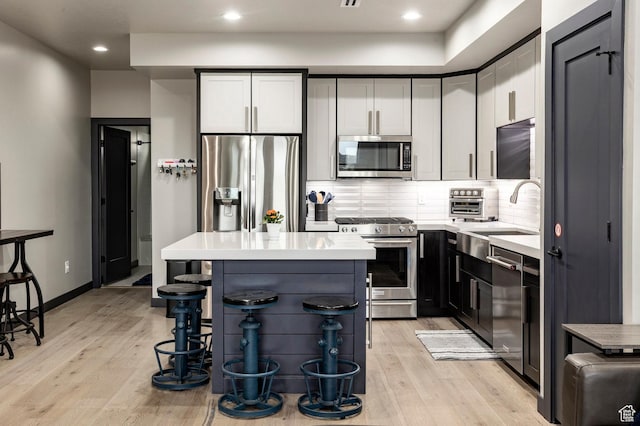 6627 Mountain Alder Way, Park City, UT 84098 - kitchen with stainless steel appliances, light wood finished floors, light countertops, a kitchen bar, and tasteful backsplash