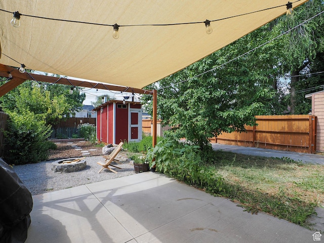 320 E Hollywood Ave S, Salt Lake City, UT 84115 - fenced backyard featuring a fire pit, a shed, and a patio