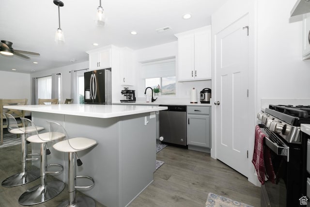 659 S Lakeside Dr, Franklin, ID 83237 - kitchen with appliances with stainless steel finishes, a breakfast bar area, a kitchen island, wood finished floors, and light countertops