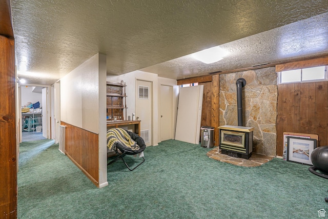 570 N 400 W, Logan, UT 84321 - basement with carpet flooring, a wood stove, a textured ceiling, and wooden walls