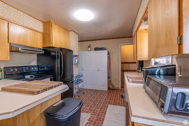 570 N 400 W, Logan, UT 84321 - kitchen featuring under cabinet range hood, black appliances, brick patterned floors, wallpapered walls, and a textured ceiling