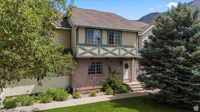 1124 S 1000 E Unit 3, Provo, UT 84606 - view of front of home featuring a shingled roof, a mountain view, brick siding, stucco siding, and a front lawn
