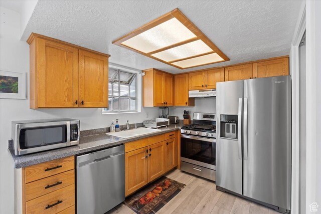 1124 S 1000 E Unit 3, Provo, UT 84606 - kitchen with stainless steel appliances, under cabinet range hood, light wood finished floors, dark countertops, and a textured ceiling