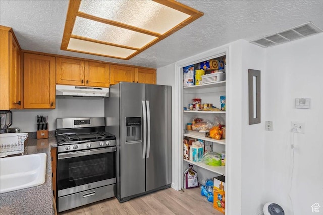 1124 S 1000 E Unit 3, Provo, UT 84606 - kitchen with stainless steel appliances, under cabinet range hood, a textured ceiling, light wood finished floors, and brown cabinets