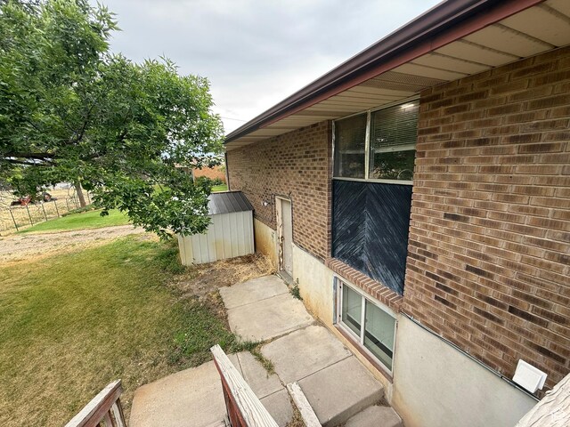 159 W 8800 S, Spanish Fork, UT 84660 - view of property exterior featuring brick siding, a storage shed, and a yard