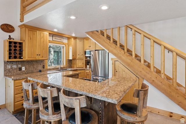 1955 Deer Valley Dr N Unit 302, Park City, UT 84060 - kitchen with stainless steel appliances, decorative backsplash, a breakfast bar area, recessed lighting, and light stone counters