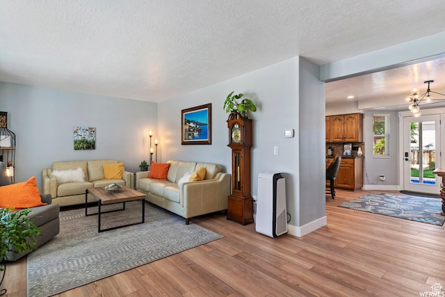 2484 W Gordon Ave, Layton, UT 84041 - living room featuring light wood-style flooring, a textured ceiling, and a chandelier