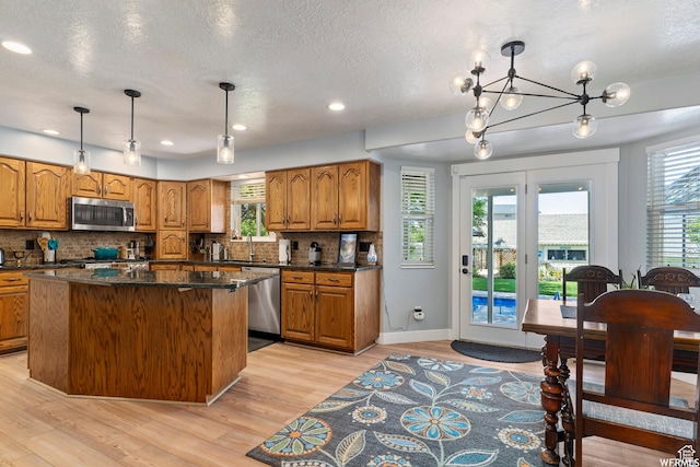 2484 W Gordon Ave, Layton, UT 84041 - kitchen featuring stainless steel appliances, brown cabinetry, tasteful backsplash, a textured ceiling, and recessed lighting
