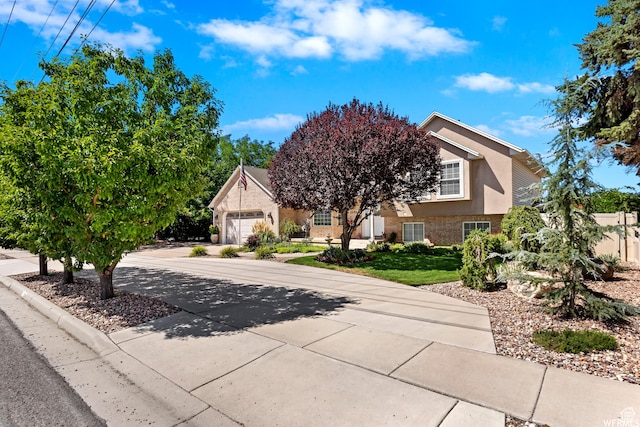 2484 W Gordon Ave, Layton, UT 84041 - obstructed view of property with concrete driveway, a garage, stucco siding, and brick siding