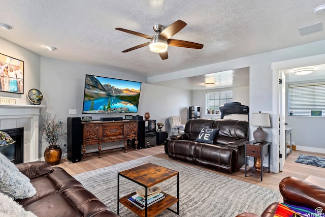 2484 W Gordon Ave, Layton, UT 84041 - living room with a ceiling fan, a textured ceiling, light wood finished floors, and a fireplace