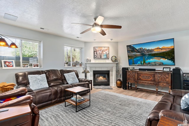 2484 W Gordon Ave, Layton, UT 84041 - living room featuring a ceiling fan, a textured ceiling, wood finished floors, and a fireplace