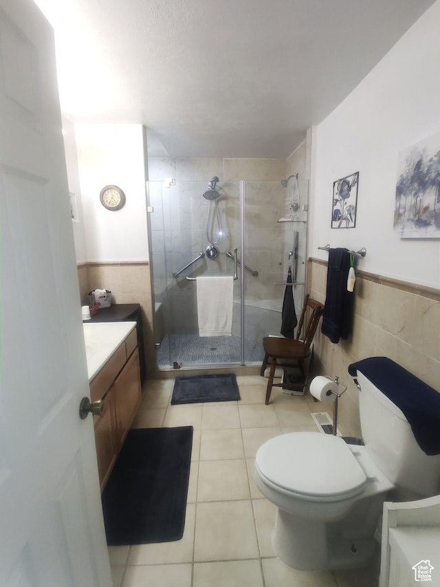 217 Wilkins, East Carbon, UT 84520 - bathroom featuring tile walls, vanity, a stall shower, tile patterned flooring, and wainscoting