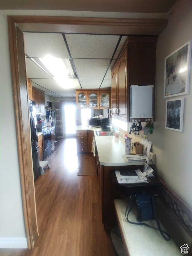 217 Wilkins, East Carbon, UT 84520 - kitchen with wood finished floors, light countertops, glass insert cabinets, a drop ceiling, and a desk
