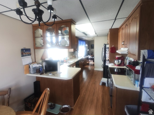 217 Wilkins, East Carbon, UT 84520 - kitchen with range hood, light countertops, dark wood-type flooring, a peninsula, and glass insert cabinets