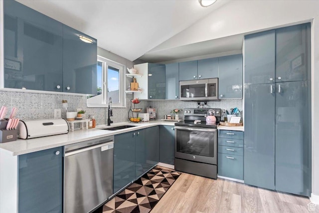 4334 W Tidwell St, Salt Lake City, UT 84118 - kitchen featuring stainless steel appliances, lofted ceiling, light countertops, decorative backsplash, and light wood-type flooring