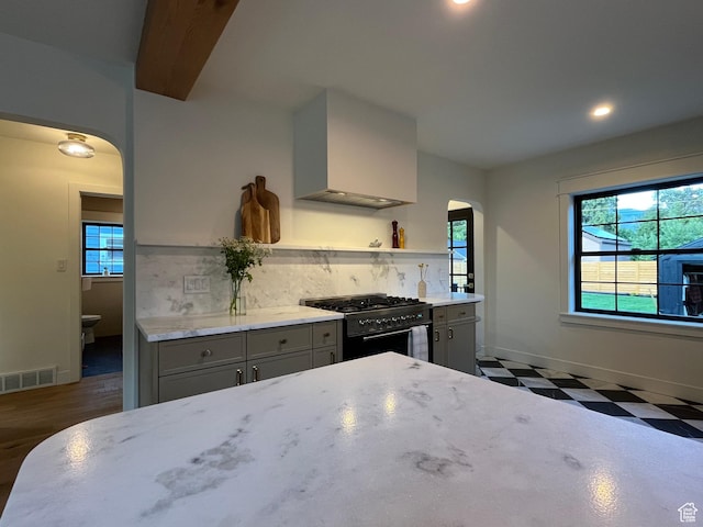 2487 S Beverly St E, Salt Lake City, UT 84106 - kitchen featuring range with gas cooktop, arched walkways, gray cabinets, premium range hood, and open shelves