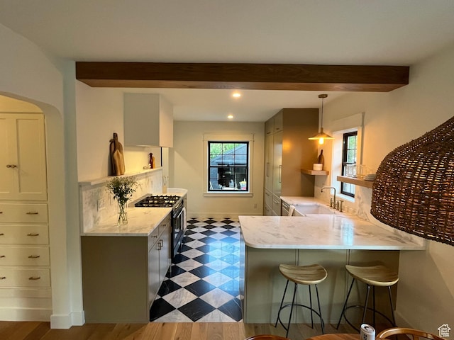 2487 S Beverly St E, Salt Lake City, UT 84106 - kitchen featuring beam ceiling, light stone counters, black range with gas cooktop, a peninsula, and a kitchen breakfast bar
