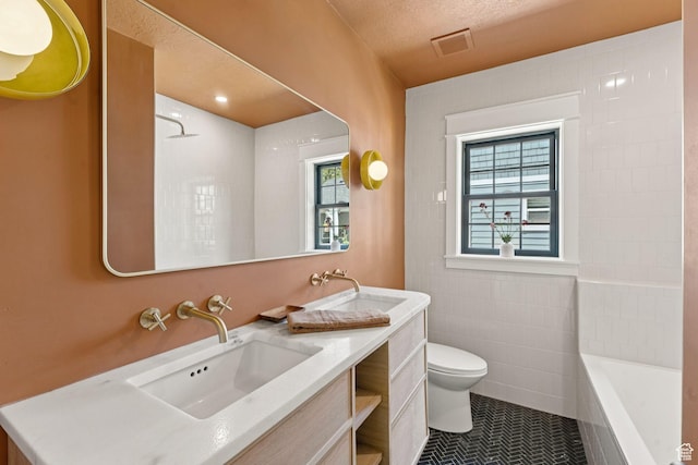 2487 S Beverly St E, Salt Lake City, UT 84106 - bathroom with vanity, tile patterned floors, a tub, plenty of natural light, and a textured ceiling