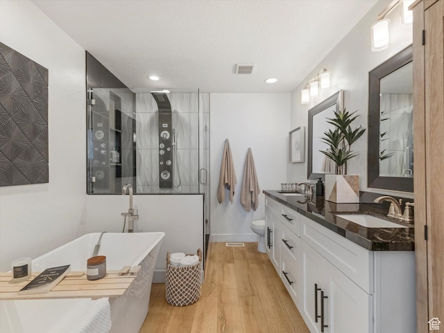 14735 S Asher Ln W, Bluffdale, UT 84065 - bathroom with a stall shower, double vanity, a freestanding bath, wood finished floors, and recessed lighting