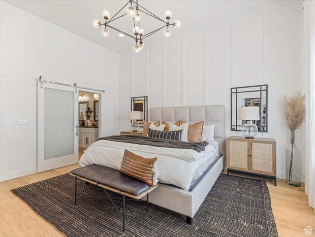 14735 S Asher Ln W, Bluffdale, UT 84065 - bedroom featuring light wood finished floors, a chandelier, a barn door, and ensuite bath