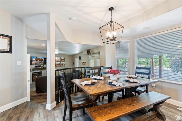 707 W 3675 S, Riverdale, UT 84405 - dining space with wood finished floors, a chandelier, and a warm lit fireplace