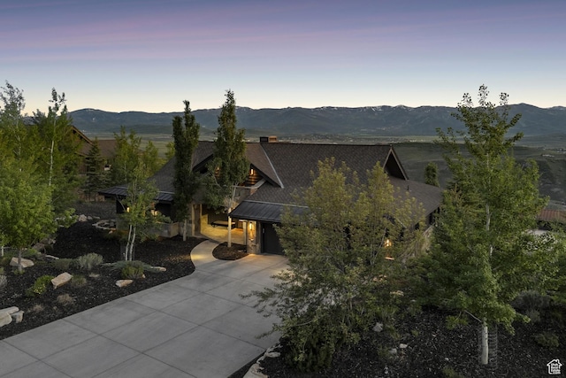 9079 Dye Cabins Dr, Park City, UT 84098 - view of front of house with a standing seam roof, concrete driveway, a mountain view, a metal roof, and a garage