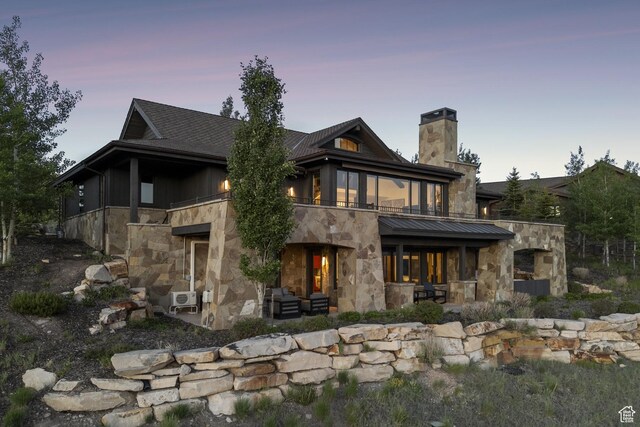 9079 Dye Cabins Dr, Park City, UT 84098 - back of property at dusk featuring stone siding, a patio, a balcony, and a chimney