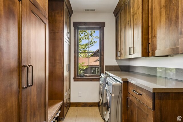 9079 Dye Cabins Dr, Park City, UT 84098 - laundry area featuring cabinet space, washer and clothes dryer, and light tile patterned floors