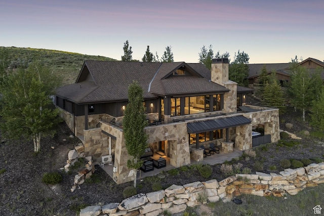 9079 Dye Cabins Dr, Park City, UT 84098 - back of house featuring stone siding, a patio, a chimney, a shingled roof, and outdoor lounge area