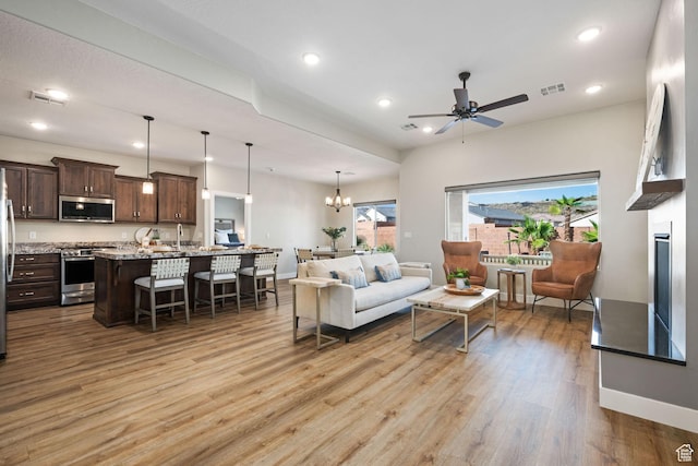 886 N Sandy Talus Dr, Washington, UT 84780 - living area with light wood finished floors, recessed lighting, ceiling fan, a chandelier, and a glass covered fireplace