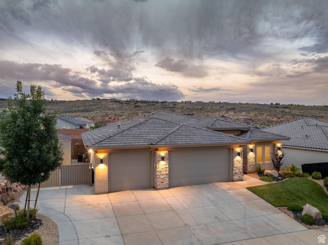 886 N Sandy Talus Dr, Washington, UT 84780 - view of front of house with concrete driveway, a garage, stone siding, stucco siding, and a tiled roof