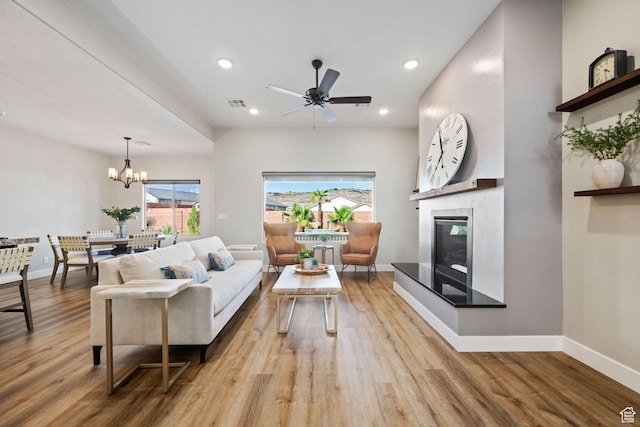 886 N Sandy Talus Dr, Washington, UT 84780 - living area featuring light wood-type flooring, ceiling fan, a glass covered fireplace, recessed lighting, and a chandelier