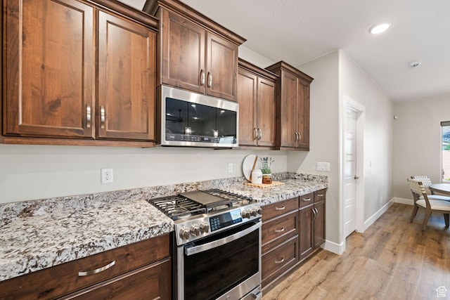 886 N Sandy Talus Dr, Washington, UT 84780 - kitchen featuring stainless steel appliances, light wood finished floors, light stone counters, recessed lighting, and dark brown cabinetry