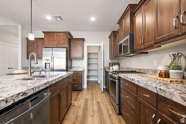 886 N Sandy Talus Dr, Washington, UT 84780 - kitchen featuring stainless steel appliances, light wood-style floors, light stone countertops, decorative light fixtures, and recessed lighting