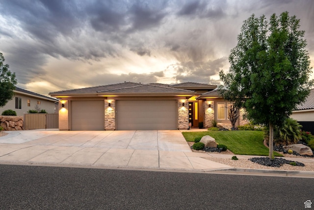 886 N Sandy Talus Dr, Washington, UT 84780 - prairie-style house with stone siding, a garage, concrete driveway, a lawn, and a tile roof