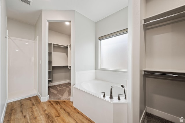 886 N Sandy Talus Dr, Washington, UT 84780 - full bathroom with a walk in closet, a garden tub, wood finished floors, and a shower