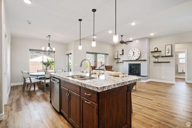 886 N Sandy Talus Dr, Washington, UT 84780 - kitchen featuring dishwasher, light wood-type flooring, a glass covered fireplace, dark brown cabinetry, and plenty of natural light