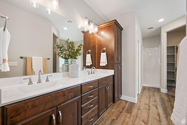 886 N Sandy Talus Dr, Washington, UT 84780 - full bath featuring wood finished floors, double vanity, and a walk in closet