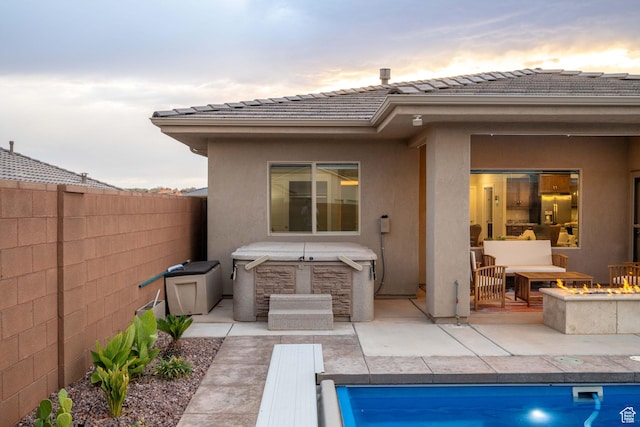 886 N Sandy Talus Dr, Washington, UT 84780 - back of property at dusk with an outdoor fire pit, stucco siding, a patio area, and a fenced backyard