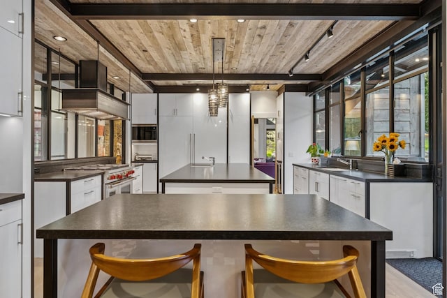 2505 W White Pine Ln, Park City, UT 84060 - kitchen featuring high end range, dark countertops, a kitchen island, built in microwave, and a wood ceiling with exposed beams