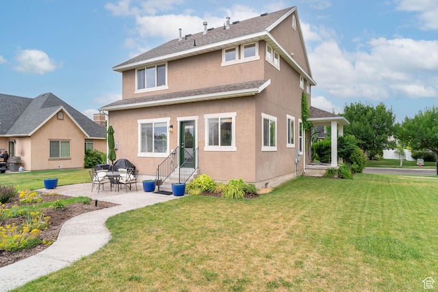 17 S Belmont Dr, Farmington, UT 84025 - rear view of property featuring a yard, a patio, stucco siding, roof with shingles, and entry steps