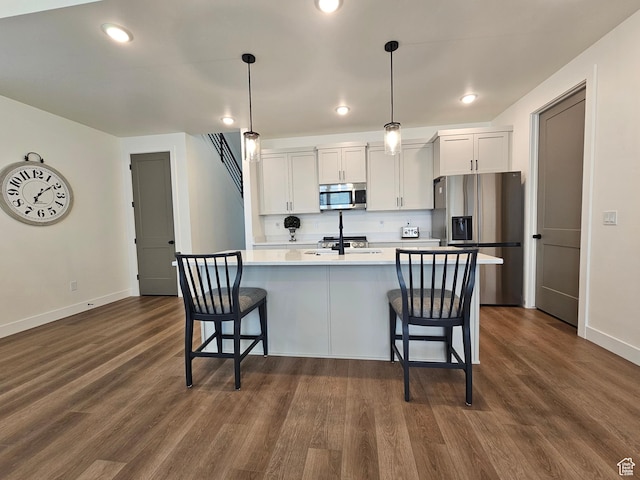 964 E 50 S, Santaquin, UT 84655 - kitchen with appliances with stainless steel finishes, a breakfast bar, dark wood-type flooring, white cabinets, and recessed lighting