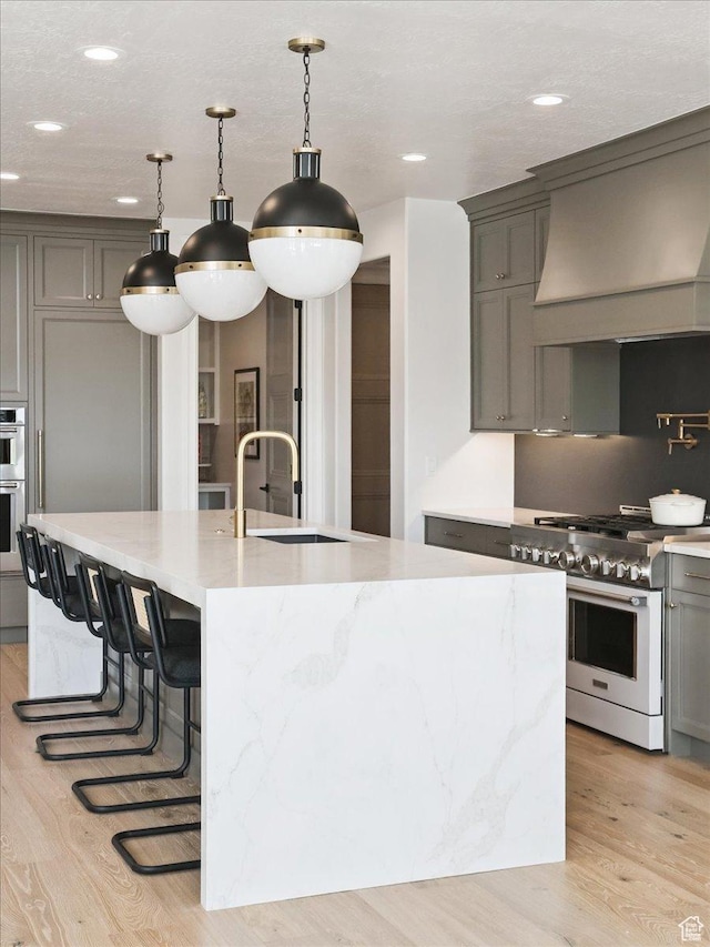 1649 W Pheasant Meadow Dr, Kaysville, UT 84037 - kitchen with stainless steel appliances, gray cabinets, light wood finished floors, recessed lighting, and custom range hood