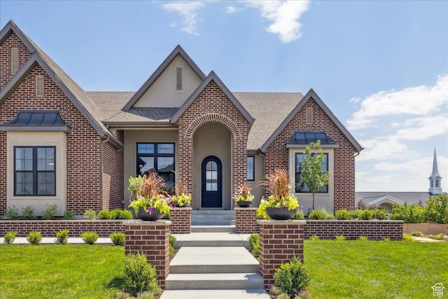 1649 W Pheasant Meadow Dr, Kaysville, UT 84037 - tudor-style house featuring roof with shingles, a front lawn, stucco siding, and brick siding