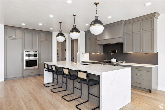 1649 W Pheasant Meadow Dr, Kaysville, UT 84037 - kitchen with double oven, custom exhaust hood, gray cabinets, light wood finished floors, and recessed lighting
