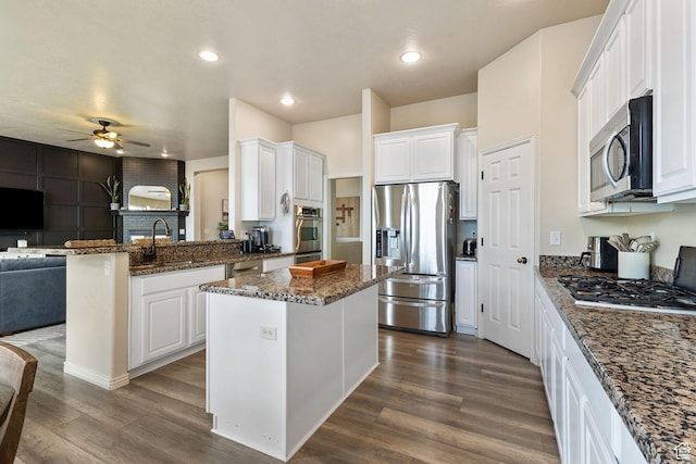 2151 E Village Vista Dr, Draper, UT 84020 - kitchen with appliances with stainless steel finishes, open floor plan, a ceiling fan, a peninsula, and dark wood-style flooring