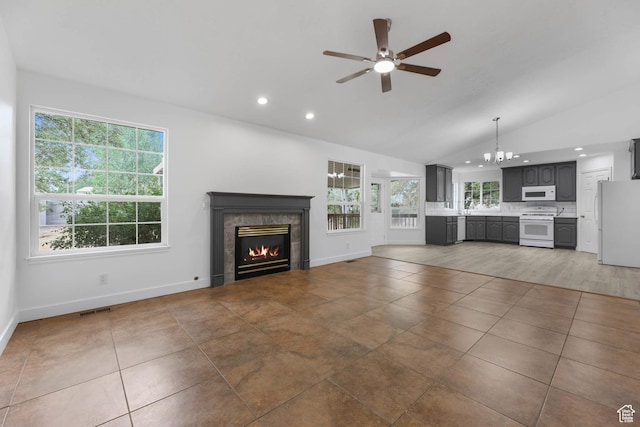 9448 S Lady Dove Ln, South Jordan, UT 84095 - unfurnished living room with vaulted ceiling, a ceiling fan, a glass covered fireplace, recessed lighting, and tile patterned floors