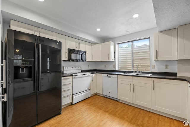 9448 S Lady Dove Ln, South Jordan, UT 84095 - kitchen featuring black appliances, dark countertops, light wood-type flooring, recessed lighting, and white cabinetry